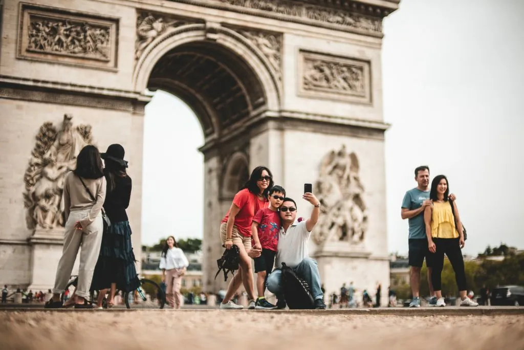 Touristes se prennent en photo devant l'Arc de Triomphe