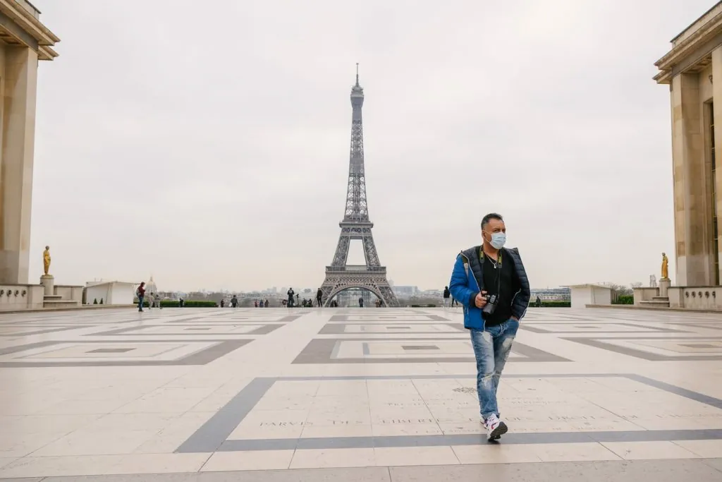 Touriste masqué devant Tour Eiffel